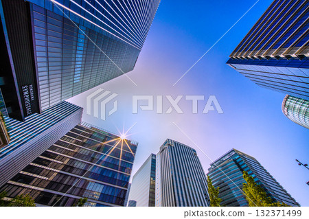 A rare sight in the cityscape of Yokohama, Japan. A mysterious sight of a pale ring surrounding the sun... View of the skyscrapers in front of Shin-Takashima Station 132371499