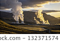 Steam rises from geothermal power plants at sunset in a mountainous landscape with clouds  132371574