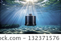 Submerged device floating in clear water with sun rays shining from above at underwater location 132371576