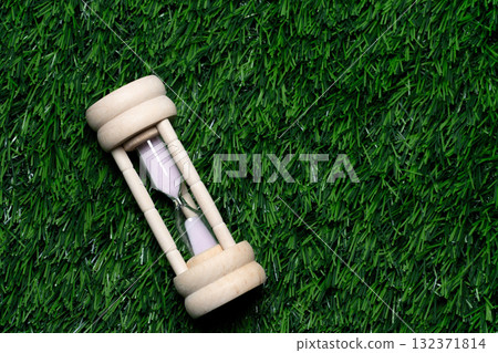 Wooden hourglass on the grass 132371814