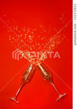 New Year's, confetti spilling out of champagne glasses on a red background New Year's, confetti spilling out of champagne glasses on a red background 132372611