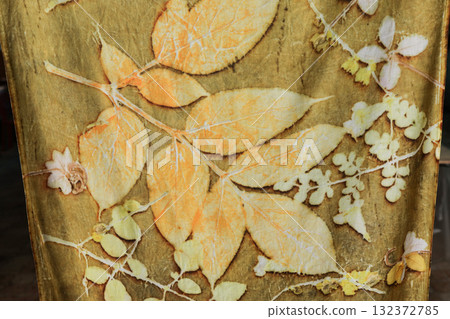 Hand dyed striped fabric using eco-print technique, leaf pattern, floral pattern, vintage floral pattern, abstract seamless fabric background and texture. Hand dyed striped fabric using eco-print technique, leaf pattern, floral pattern, vintage floral pattern, abstract seamless fabric background and texture. 132372785