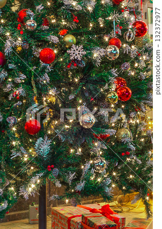 Decorated Christmas or New Year's tree, adorned with Christmas tree ornaments and garlands that glow and sparkle 132372977