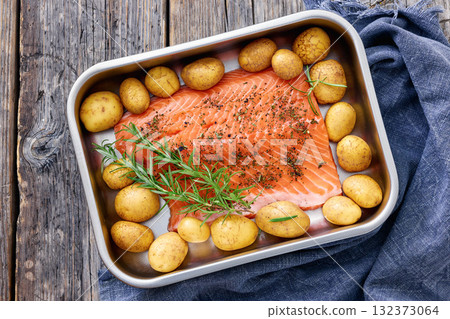 raw salmon fillet with baby potato in baking dish raw salmon fillet with baby potato in baking dish 132373064