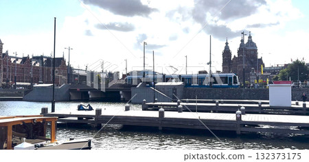 Train Arrives in the Vibrant City of Amsterdam by the Waterfront 132373175