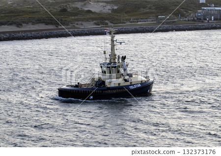 Tugboat Cruising Through Calm Waters Near the Coastline 132373176