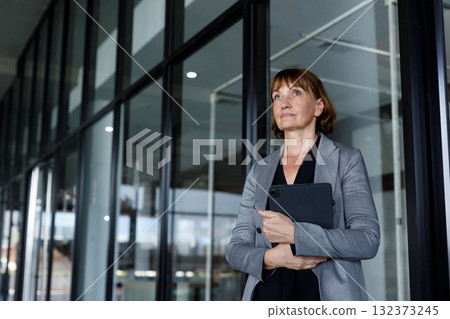 Professional senior businesswoman holding digital tablet in modern office, representing leadership, technology adoption, confidence, and strategic planning in corporate environment. Professional senior businesswoman holding digital tablet in modern office, representing leadership, technology adoption, confidence, and strategic planning in corporate environment. 132373245