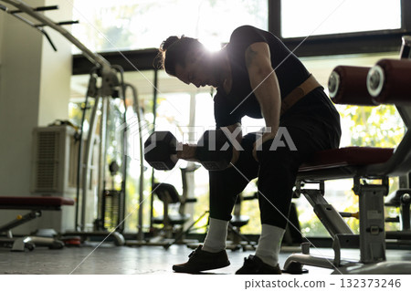Strong male athlete lifting heavy dumbbell during intense arm workout in modern gym, focused on strength training, bodybuilding and fitness lifestyle. Strong male athlete lifting heavy dumbbell during intense arm workout in modern gym, focused on strength training, bodybuilding and fitness lifestyle. 132373246