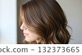 A striking rear view of a woman with beautiful hair dyed a vibrant medium brown color 132373665