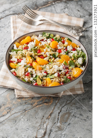 Winter Pomegranate Orange Quinoa Salad with spinach, feta, and pistachios closeup on the plate. Vertical Winter Pomegranate Orange Quinoa Salad with spinach, feta, and pistachios closeup on the plate. Vertical 132373921
