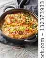 Million Dollar Chicken breast is layered with a velvety mixture of two kinds of cheese, bacon, and green onions and baked to tender, juicy perfection closeup on the pan. Vertical 132373933