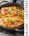 Million Dollar Chicken with cream cheese, bacon, cheese, scallions and almonds closeup on the pan. Vertical 132373934