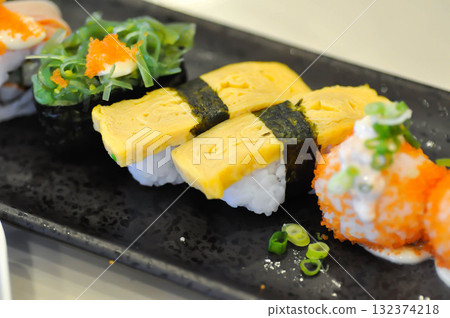 sushi or egg sushi , rice topped with egg and shrimp sushi or steam egg roll and seaweed roll sushi or egg sushi , rice topped with egg and shrimp sushi or steam egg roll and seaweed roll 132374218