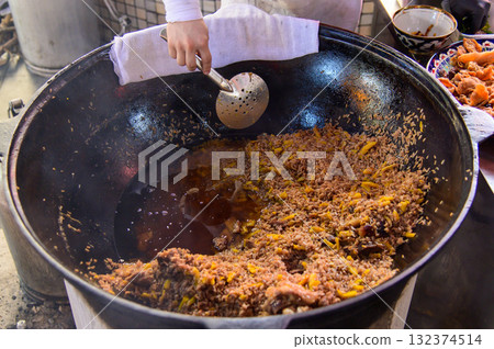Delicious plov, a famous national dish of Uzbekistan, cooked in a large pot. Delicious plov, a famous national dish of Uzbekistan, cooked in a large pot. 132374514