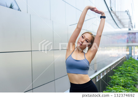 Stretch woman sport exercise workout fit outdoor people, performing invigorating routine, engaging full body stretch, finding energy and flexibility in urban environment 132374692