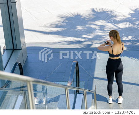 Sport woman looking at smartwatch, preparing for workout outdoor exercise session, people pursuing fit lifestyle, staying active for overall health and daily exercise Sport woman looking at smartwatch, preparing for workout outdoor exercise session, people pursuing fit lifestyle, staying active for overall health and daily exercise 132374705