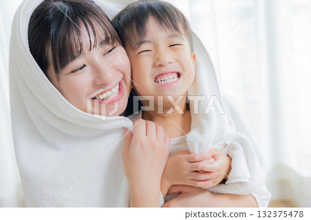 Mom wiping her child with a towel Mom wiping her child with a towel 132375478