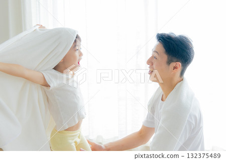 A father wiping his child with a towel after a bath 132375489