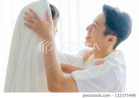 A father wiping his child with a towel after a bath A father wiping his child with a towel after a bath 132375490