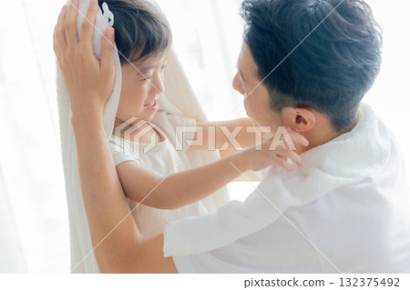 一位父親在孩子洗完澡後用毛巾擦拭 一位父親在孩子洗完澡後用毛巾擦拭 132375492