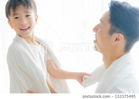 A father wiping his child with a towel after a bath 132375495