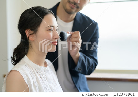 Man applying make-up to a woman Man applying make-up to a woman 132375901