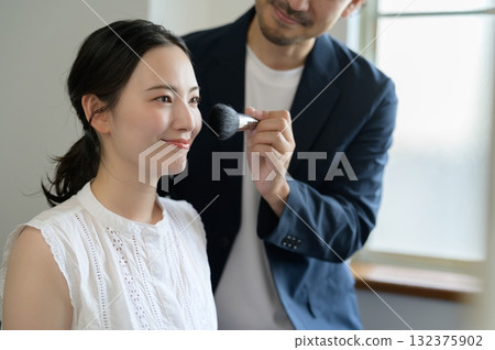 Man applying make-up to a woman Man applying make-up to a woman 132375902