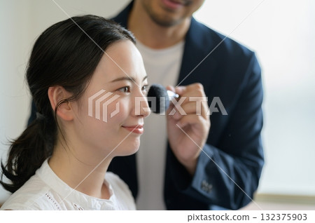 Man applying make-up to a woman Man applying make-up to a woman 132375903