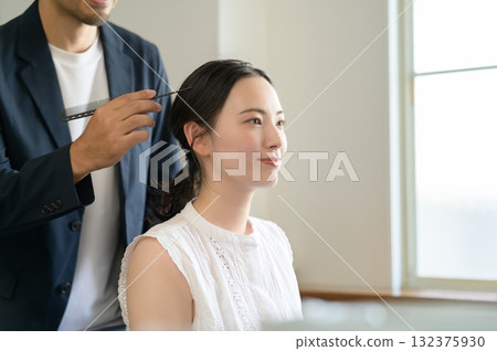 Man applying make-up to a woman Man applying make-up to a woman 132375930