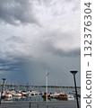 Yachts and sailboats moored at a pier under a stormy sky 132376304