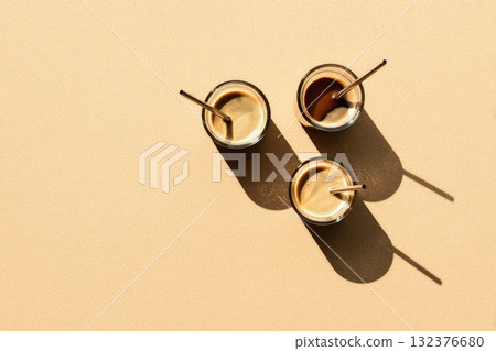 Delicious Coffee Drinks With Straws Arranged on a Warm Background in an Inviting Setting 132376680