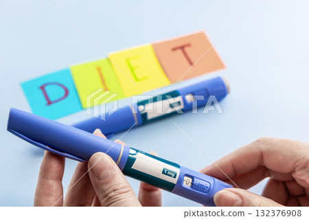 Ozempic pen for diabetics in female hands and diet abbreviation on multi-colored paper 132376908
