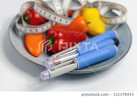Ozempic Insulin injection pen for diabetics and weight loss on plate with vegetables 132376933