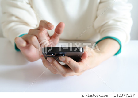 A woman looking at a smartphone 132377137