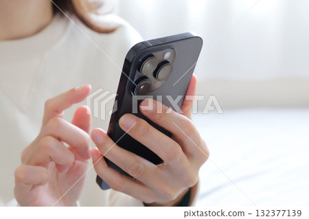 A woman looking at a smartphone 132377139