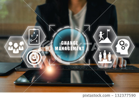 Visual representation of change management with digital icons and a professional using a tablet, symbolizing strategy and innovation. 132377590