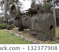 A vintage steam-powered machine with large metallic wheels and a cylindrical body. 132377908