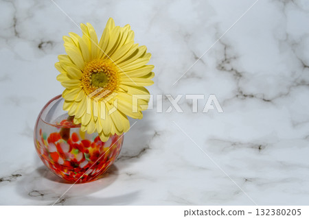 玻璃花瓶中插著一朵暖黃色的非洲菊（放在左邊，朝右） 132380205