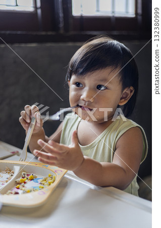 Toddler Is Eating Breakfast By Himself, Toddler eats breakfast independently at a cozy table, great for promoting safe, sustainable toddler feeding gear. Toddler Is Eating Breakfast By Himself, Toddler eats breakfast independently at a cozy table, great for promoting safe, sustainable toddler feeding gear. 132380999