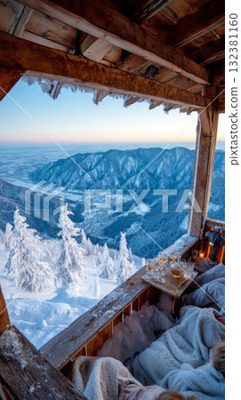 The winter vacation chalet features a warm interior with blankets and drinks, showcasing breathtaking mountain views enveloped in a serene snow-covered landscape The winter vacation chalet features a warm interior with blankets and drinks, showcasing breathtaking mountain views enveloped in a serene snow-covered landscape 132381160