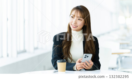 Smiling woman/businesswoman using a smartphone Smiling woman/businesswoman using a smartphone 132382295