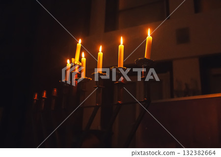 Glowing Hanukkah candles burning in complete darkness, symbolizing light, faith, and Jewish holiday tradition. Glowing Hanukkah candles burning in complete darkness, symbolizing light, faith, and Jewish holiday tradition. 132382664