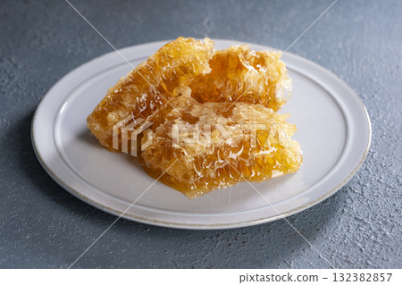 Golden comb honey served on a white plate 132382857