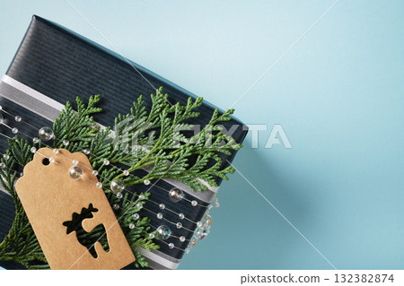 Banner with a fragment of a blue gift box with a gift tag on a light blue background. Copy space. Banner with a fragment of a blue gift box with a gift tag on a light blue background. Copy space. 132382874