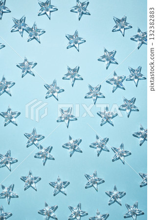 Transparent crystal stars on a light blue background with shadows. 132382883