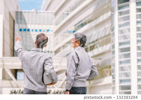 一個穿著工作服的人站在一個建築工地 一個穿著工作服的人站在一個建築工地 132383204