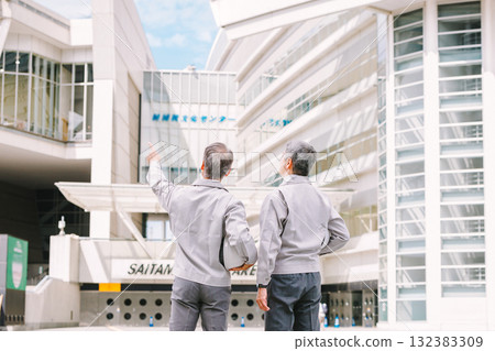 A man in work clothes standing at a construction site 132383309