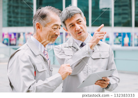 A man in work clothes standing at a construction site A man in work clothes standing at a construction site 132383333