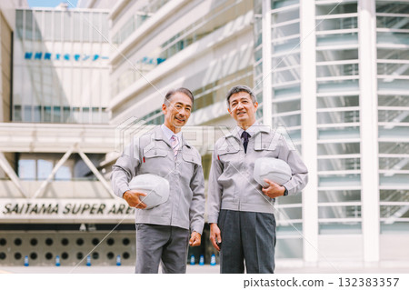 A man in work clothes standing at a construction site A man in work clothes standing at a construction site 132383357