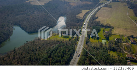 Scenic highway view near a lake and fields in rural landscape 132383409